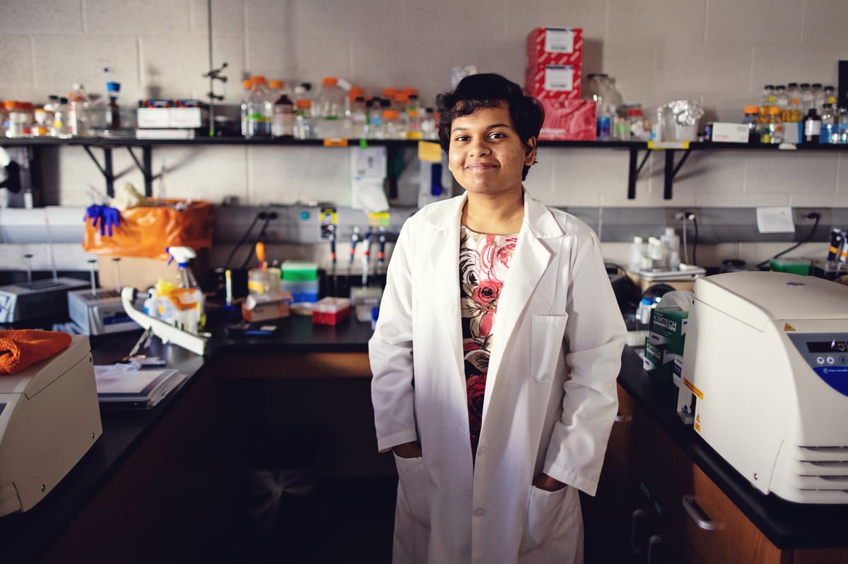 A girl wearing a lab coat standing in a science laboratory