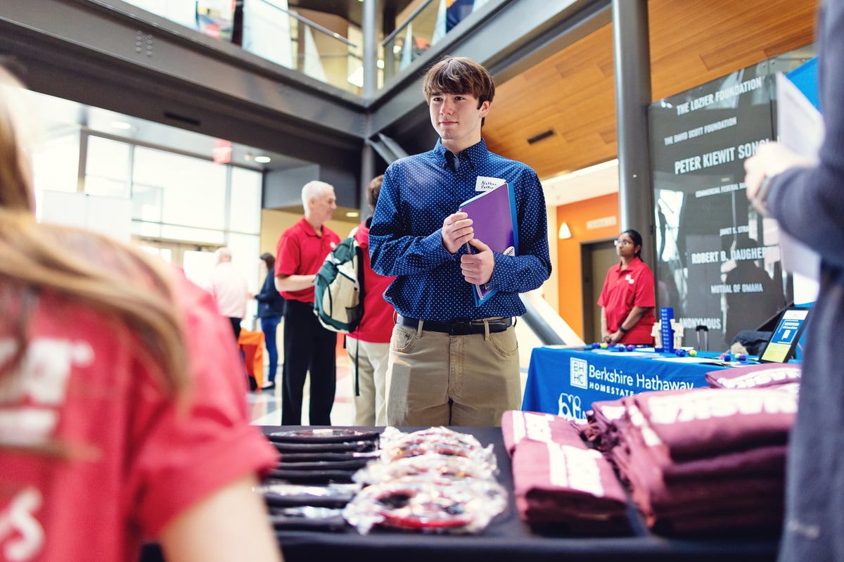 Young man holding a folder at a career fair