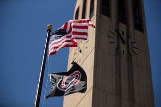 American Flag and UNO Flag fly in front of the Campanile.