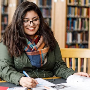Student studying in library facing camera