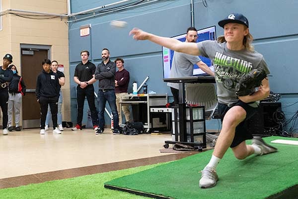 A student from Benson High School throws a baseball in UNO's Pitching Lab