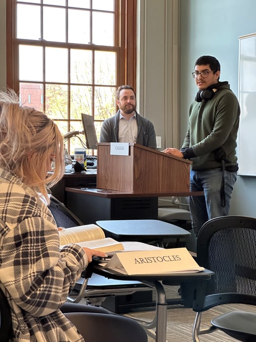 Cole Stormberg helps students with a classroom activity