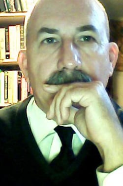 Dr. James Clark sits in his office, books are displayed in the background