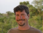 Dr. Edwin Barnhart stands outside in front of trees